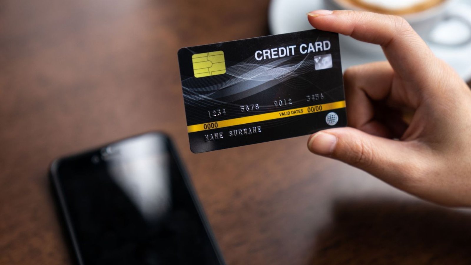 A Person holding a Black Credit Card
